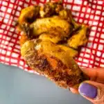 Person holding a crispy air fryer chicken wing