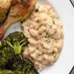 Parmesan Beans served on a plate with chicken and broccoli