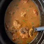 Cooked Salisbury Steak with gravy in a black slow cooker